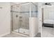 Modern walk-in shower with gray tile and built-in shelves, connected to the main bedroom at 8807 Interlocking Ct, Davenport, FL 33896