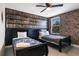 Bedroom with two beds, a fan, and a brick-themed accent wall, featuring views from the window at 8807 Interlocking Ct, Davenport, FL 33896
