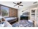 Bedroom with two beds, a fan, a brick-themed accent wall, and a view into another bedroom at 8807 Interlocking Ct, Davenport, FL 33896