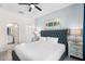 Comfortable bedroom features a gray bed, wood-look flooring, ceiling fan, and a view of the ensuite bathroom at 8807 Interlocking Ct, Davenport, FL 33896