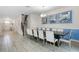 Elegant dining area features a long dining table with seating for ten, modern lighting, and neutral decor at 8807 Interlocking Ct, Davenport, FL 33896