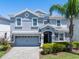 Charming two-story home featuring a gray exterior, well-manicured lawn, and a two-car garage at 8807 Interlocking Ct, Davenport, FL 33896