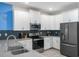 Modern kitchen features white cabinets, stainless steel appliances, and sleek countertop at 8807 Interlocking Ct, Davenport, FL 33896
