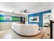 A modern living room area featuring a ceiling fan, blue accent wall and a stylish white curved couch at 8807 Interlocking Ct, Davenport, FL 33896