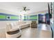 Living room with a fan, blue and green stripes on the wall, and a white couch at 8807 Interlocking Ct, Davenport, FL 33896