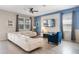 Cozy living room features a large white sectional, a blue accent chair, and a mounted TV at 8807 Interlocking Ct, Davenport, FL 33896