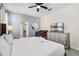 Well-lit main bedroom featuring a ceiling fan, a baby crib, a dresser with TV, and an ensuite bathroom at 8807 Interlocking Ct, Davenport, FL 33896