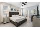 Comfortable main bedroom with a tufted headboard, ceiling fan, and a convenient ensuite bathroom at 8807 Interlocking Ct, Davenport, FL 33896