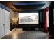 Entertainment area featuring a large screen, comfortable seating, and elegant wood flooring for a cinematic experience at 8807 Interlocking Ct, Davenport, FL 33896