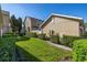 Exterior side yard with green grass, neatly trimmed shrubs, and views of the adjacent townhomes at 9141 Camden Gardens St, Orlando, FL 32827