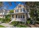 Inviting two-story home boasts a charming front porch, black shutters, and well-maintained landscaping at 9141 Camden Gardens St, Orlando, FL 32827