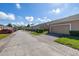 Exterior view of townhomes with beige exteriors, garages, and well-maintained landscaping at 9141 Camden Gardens St, Orlando, FL 32827