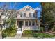 Charming two-story home featuring a cozy front porch with white railings and lush landscaping at 9141 Camden Gardens St, Orlando, FL 32827