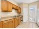 Clean kitchen featuring tile flooring, wood cabinets, and access to the backyard at 9141 Camden Gardens St, Orlando, FL 32827