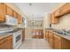 Well-lit kitchen featuring tile floors, wood cabinets, and white appliances at 9141 Camden Gardens St, Orlando, FL 32827