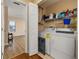 Functional laundry room with a washing machine, dryer, and storage shelves at 9141 Camden Gardens St, Orlando, FL 32827