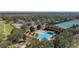 Aerial view displays tennis courts, community pool, and the building amidst picturesque landscapes at 9141 Camden Gardens St, Orlando, FL 32827