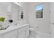 Bright bathroom with a white quartz vanity top, decorative mirror and sleek fixtures at 9845 Emerald Berry Dr, Winter Garden, FL 34787