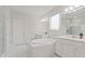 This luxurious bathroom features marble tile, dual sinks, soaking tub, and a glass shower at 9845 Emerald Berry Dr, Winter Garden, FL 34787