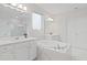 This luxurious bathroom features marble tile, dual sinks, soaking tub, and a glass shower at 9845 Emerald Berry Dr, Winter Garden, FL 34787