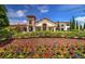 Stunning clubhouse with stone tower, terracotta roof, and lush landscaping, inviting community gatherings at 9845 Emerald Berry Dr, Winter Garden, FL 34787