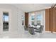 Bright dining room area with a glass table, seating for six, and natural light from the windows at 9845 Emerald Berry Dr, Winter Garden, FL 34787