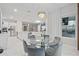 Elegant dining area featuring a glass table, seating for six, and natural light flowing from large windows at 9845 Emerald Berry Dr, Winter Garden, FL 34787