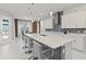 A stylish kitchen showcases a large island with quartz countertops and sleek bar stool seating, plus modern appliances at 9845 Emerald Berry Dr, Winter Garden, FL 34787