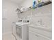 Efficient laundry room with modern washer and dryer, sink, and ample storage space at 9845 Emerald Berry Dr, Winter Garden, FL 34787