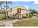Inviting two-story condo with charming yellow siding, lush landscaping, and convenient exterior staircase access at 1031 S Hiawassee Rd # 2517, Orlando, FL 32835