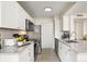 Bright kitchen features sleek white cabinets, stainless steel appliances, and elegant gray countertops at 1031 S Hiawassee Rd # 2517, Orlando, FL 32835