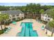 Aerial view of a community pool with lounge chairs, tables, umbrellas, and palm trees at 1031 S Hiawassee Rd # 2517, Orlando, FL 32835