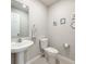 A well-lit powder room featuring a pedestal sink, framed mirror, and ceramic tile flooring at 1045 Desert Candle Dr, Ocoee, FL 34761
