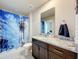 Bathroom features granite counters, single sink vanity and shower with blue patterned shower curtain at 1045 Desert Candle Dr, Ocoee, FL 34761