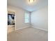 Bright bedroom featuring neutral carpet, a window with blinds, and access to an ensuite bathroom at 1045 Desert Candle Dr, Ocoee, FL 34761