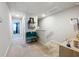 Bright hallway with neutral carpet, leading to bedrooms, and decorated with stylish turquoise chairs at 1045 Desert Candle Dr, Ocoee, FL 34761