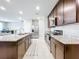 Modern kitchen featuring stainless steel appliances, granite countertops and dark brown cabinetry at 1045 Desert Candle Dr, Ocoee, FL 34761
