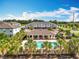 A beautiful pool area featuring clear blue water and a charming open-air clubhouse lined by palm trees offering shady seating at 1045 Desert Candle Dr, Ocoee, FL 34761