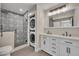 Updated bathroom features patterned tile in shower, modern dual vanity, and stackable washer/dryer at 1120 Courtland St, Orlando, FL 32804