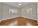 This bedroom features hardwood floors, two windows, and a ceiling fan at 1120 Courtland St, Orlando, FL 32804