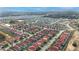 Expansive aerial view of a neighborhood with neatly lined homes and community amenities, including a pond and green spaces at 117 Rosso Dr, Davenport, FL 33837