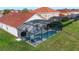 Aerial view of a screened in pool and patio area with a red tile roof at 117 Rosso Dr, Davenport, FL 33837