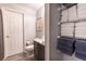 Bathroom features a vanity with a dark countertop, and shower/tub with a gray curtain, with linen shelves at 117 Rosso Dr, Davenport, FL 33837
