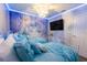 Themed bedroom with a full wall mural, matching bedding, and ambient ceiling lighting at 117 Rosso Dr, Davenport, FL 33837
