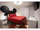 Bedroom features a comfortable bed with red linens, wall art and television at 117 Rosso Dr, Davenport, FL 33837
