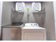Modern laundry room with front loading washer and dryer, complemented by storage shelves at 117 Rosso Dr, Davenport, FL 33837
