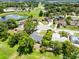 Aerial view of a residential neighborhood with lush greenery, a pond, and houses with varying roof designs at 12929 Louisiana Woods Ct, Orlando, FL 32824
