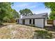 View of home's backyard featuring a well-maintained lawn, mature trees and side fencing at 12929 Louisiana Woods Ct, Orlando, FL 32824