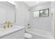 Elegant bathroom featuring a white vanity, marble-like tile, contemporary fixtures and a bathtub at 12929 Louisiana Woods Ct, Orlando, FL 32824