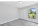 Clean bedroom with neutral walls, carpet flooring, large window offering a view, and a closet at 12929 Louisiana Woods Ct, Orlando, FL 32824